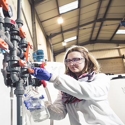 PhD student taking water sample