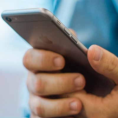 Someone hold a mobile phone in their hand. 