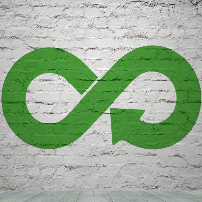 Green recycle symbol on brick wall close up