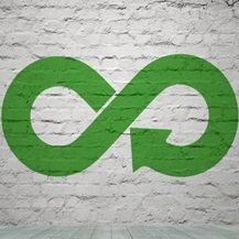 Green recycle symbol on brick wall close up