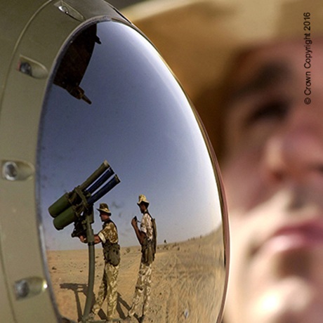 mirror reflection of soldiers loading gun missiles